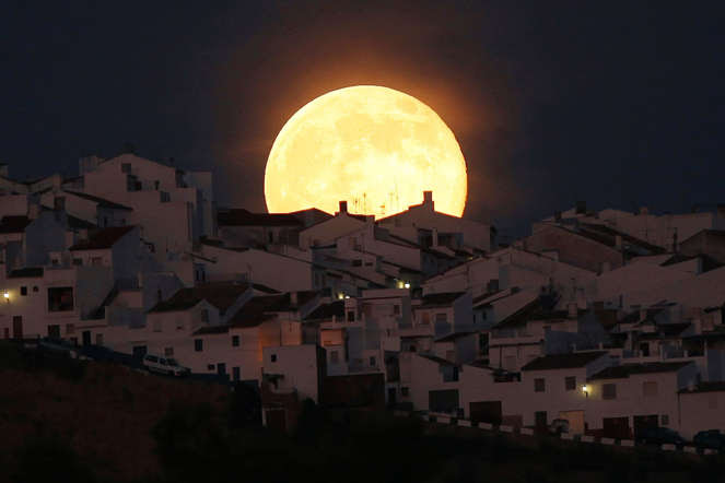 The Supermoon rises over houses in Olvera, in the southern Spanish province of Cadiz, July 12, 2014.
