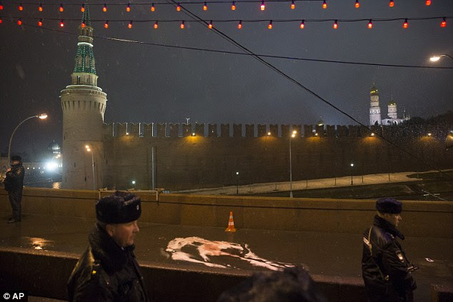 Russian police officers stand next to traces of Boris Nemtsov's body on a bridge in central Moscow