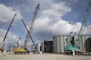 Workers are seen near welding storage tanks for radioactive water, under construction in the J1 area at the Fukushima Daiichi nuclear power plant in Fukushima