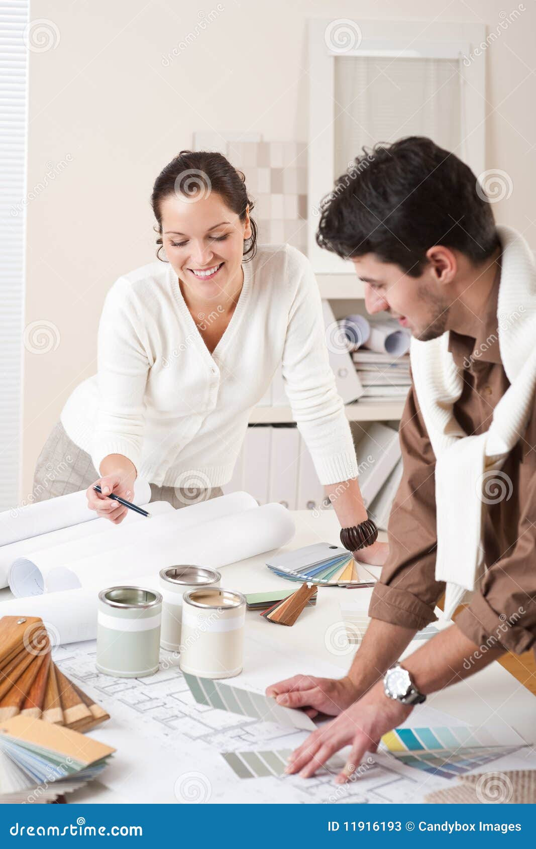 Two interior designer working at office with color swatch and can of 