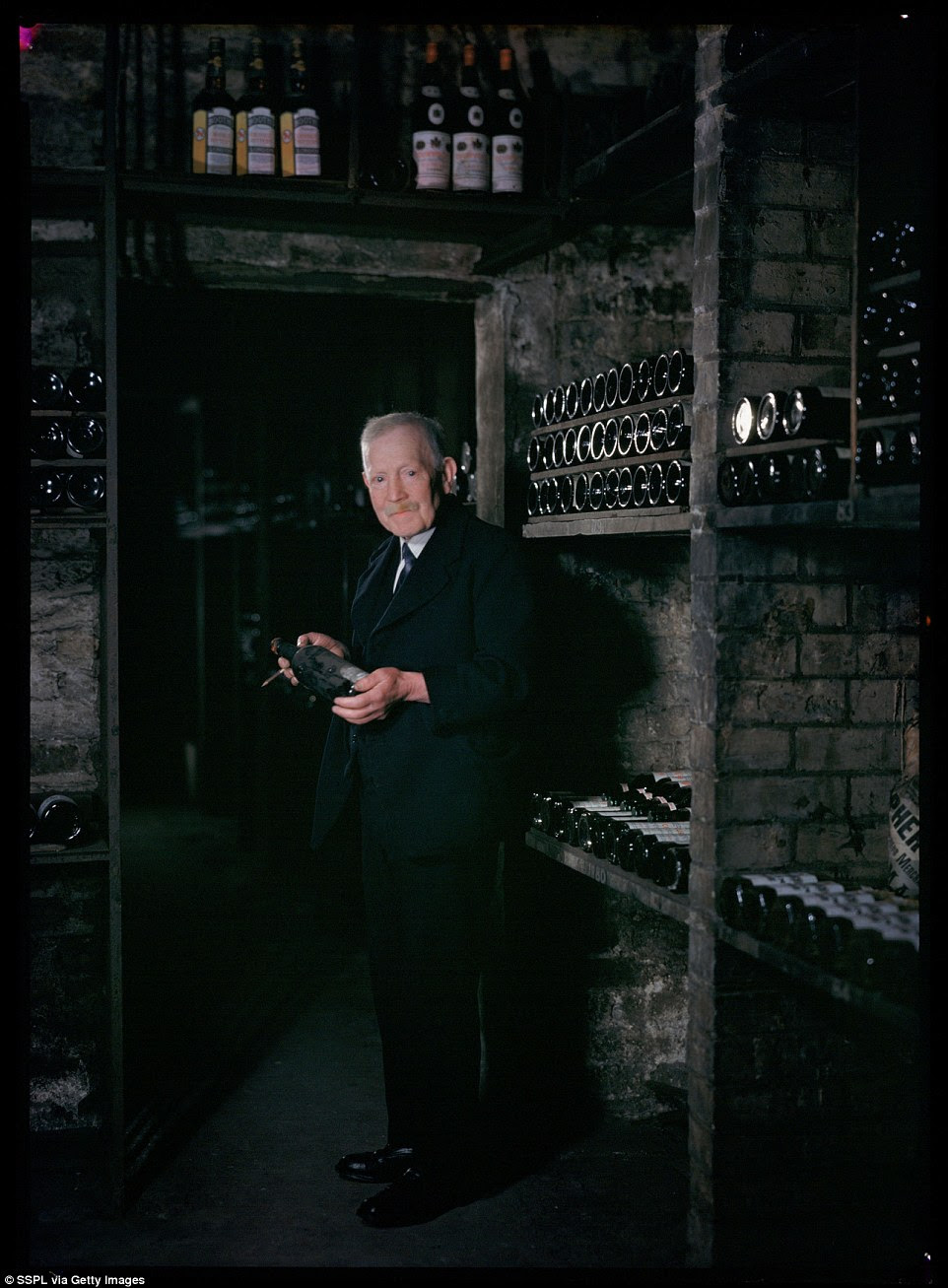 George Hill(1887-1952). The wine cellar clerk, is photographed in the wine cellar of the Reform Club on Pall Mall, London, a gentleman's club dating back to the 1830s. The club was used as the headquarters of the Liberal Party in the 19th Century, but is now simply used as a social venue with no association to any political organisations