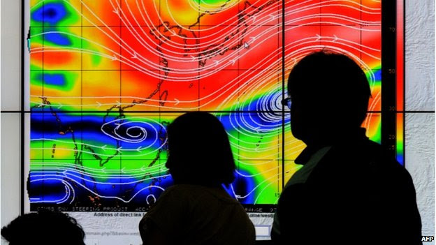 Meteorologists from the Philippine Atmospheric, Geophysical and Astronomical Services Administration (PAGASA) monitor and plot the direction of super typhoon Hagupit at PAGASA in suburban Manila on 4 December 2014. 