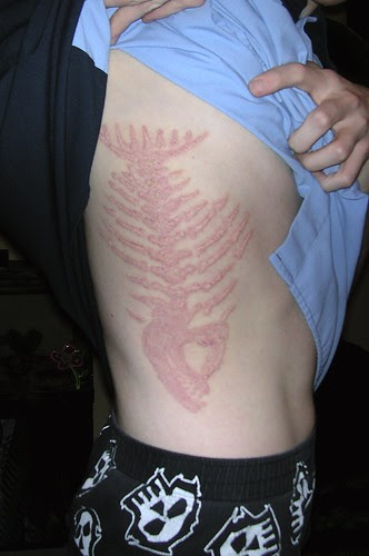 Spott sports giant skeleton tattoos on his torso.