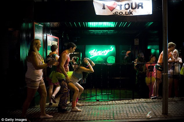 Shameless: A passerby cheers as two partygoers get up close and personal outside an Irish-themed bar