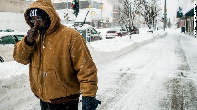 A man warms his hand while running errands in Flint, Michigan, on Monday, January 6. 