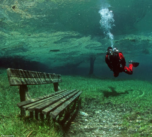 
A rare natural phenomenon turns one of Austria’s most beautiful hiking trails into a 10 meter-deep lake, for half the year.
Located at the foot of the Hochschwab Mountains, in Tragoess, Styria, Green Lake is one of the most bizarre natural phenomena in the world. During the cold winter months, this place is almost completely dry, and used as a country park where hikers love to come and spend some time away from urban chaos. But as soon as temperatures rise, the snow and ice covering the mountaintops begin to melt, and the water pours down, filling the basin below with crystal-clear water.
Water levels go from one-two meters at most, to over 10 meters, in the early summer. The waters of Green Lake are highest in June, when this extraordinary place is invaded by divers, curious to see what a mountain park looks like underwater. Fish swimming over wooden benches, a grass-covered bottom, trees, roads, roads and even bridges create a surreal setting that feels like it belongs on dry ground. That’s because for half of the year, that’s exactly where it’s at.
