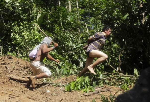 Guerreiro indígena tenta capturar madeireiro que fugiu durante operação independente feita pela tribo Ka'apor, no Maranhão (Foto: Lunaé Parracho/Reuters)