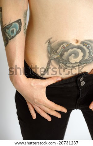 stock photo : Young woman showing her lower stomach tattoo.