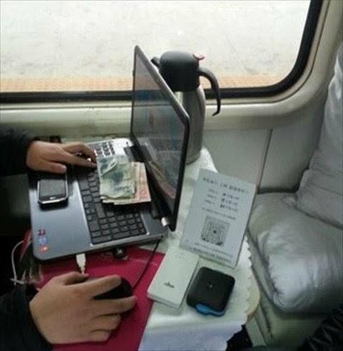 Clicks for cash: Wang attends to his Wi-Fi service station on his train back home from school. Photo: Chinanews.com