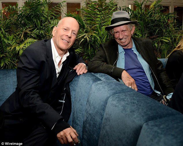 Dynamic duo: The Die Hard star and 71-year-old Rolling Stones member sat in booths next to each other as they posed for a photo together 
