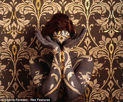 Dourada senhora: Ms Paredes é pintado com motivos em preto e dourado (esquerda) e seu corpo é pintado para combinar com o wallpaper você pode ver um vislumbre de para a esquerda da foto (à direita)