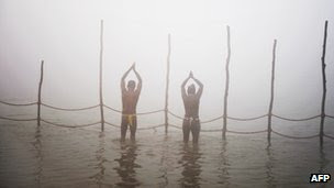Devotees pray while taking a dip at the Sangham or confluence of the Yamuna and Ganges river at day break at the Kumbh Mela celebration in Allahabad on January 13, 2013.