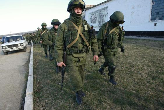 Military personnel, believed to be Russian servicemen, walk outside the territory of a Ukrainian military unit in the village of Perevalnoye outside Simferopol March 3, 2014. REUTERS/David Mdzinarishvili