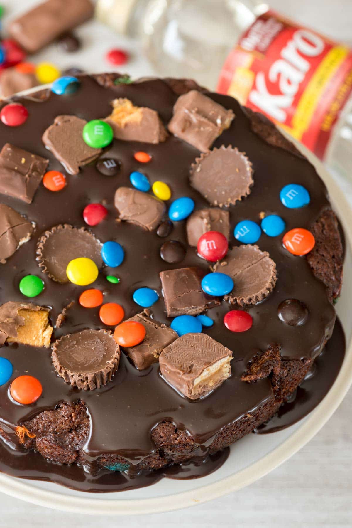 Gooey Candy Brownie Pie - this EASY brownie recipe is baked like a cake, FILLED with candy, and topped with a pourable chocolate frosting. It's chocolate heaven!