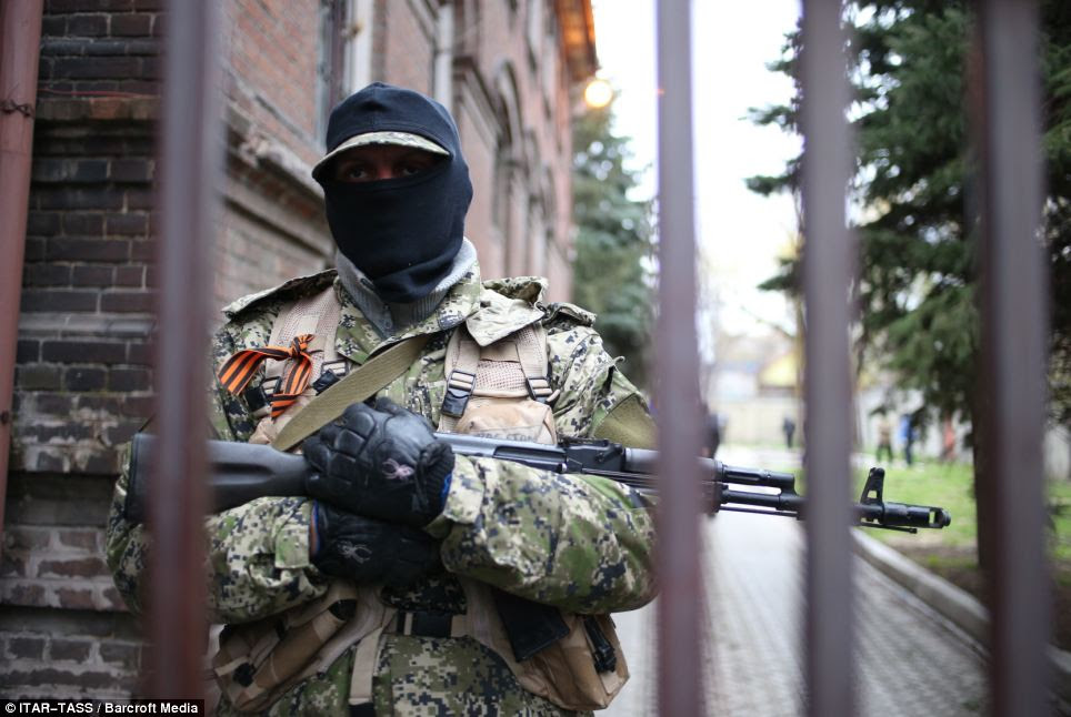A member of the People's Militia of Donbass, who are pro-Ukraine, stands outside the local office of Ukraine's Security Service today