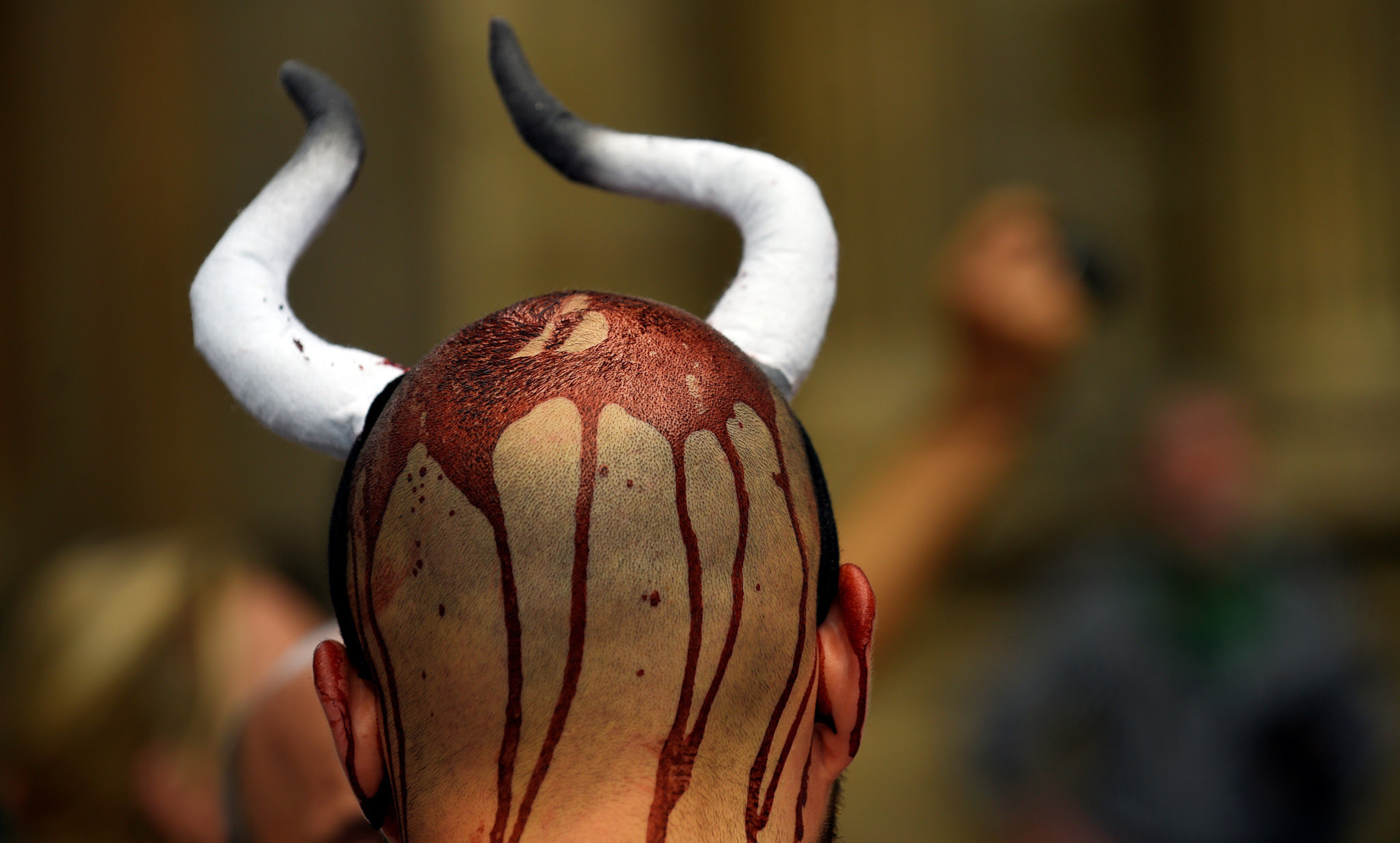 An animal rights protester covered in fake blood demonstrate for the abolition of bull runs and bullfights a day before the start of the famous running of the bulls San Fermin festival in Pamplona, northern Spain