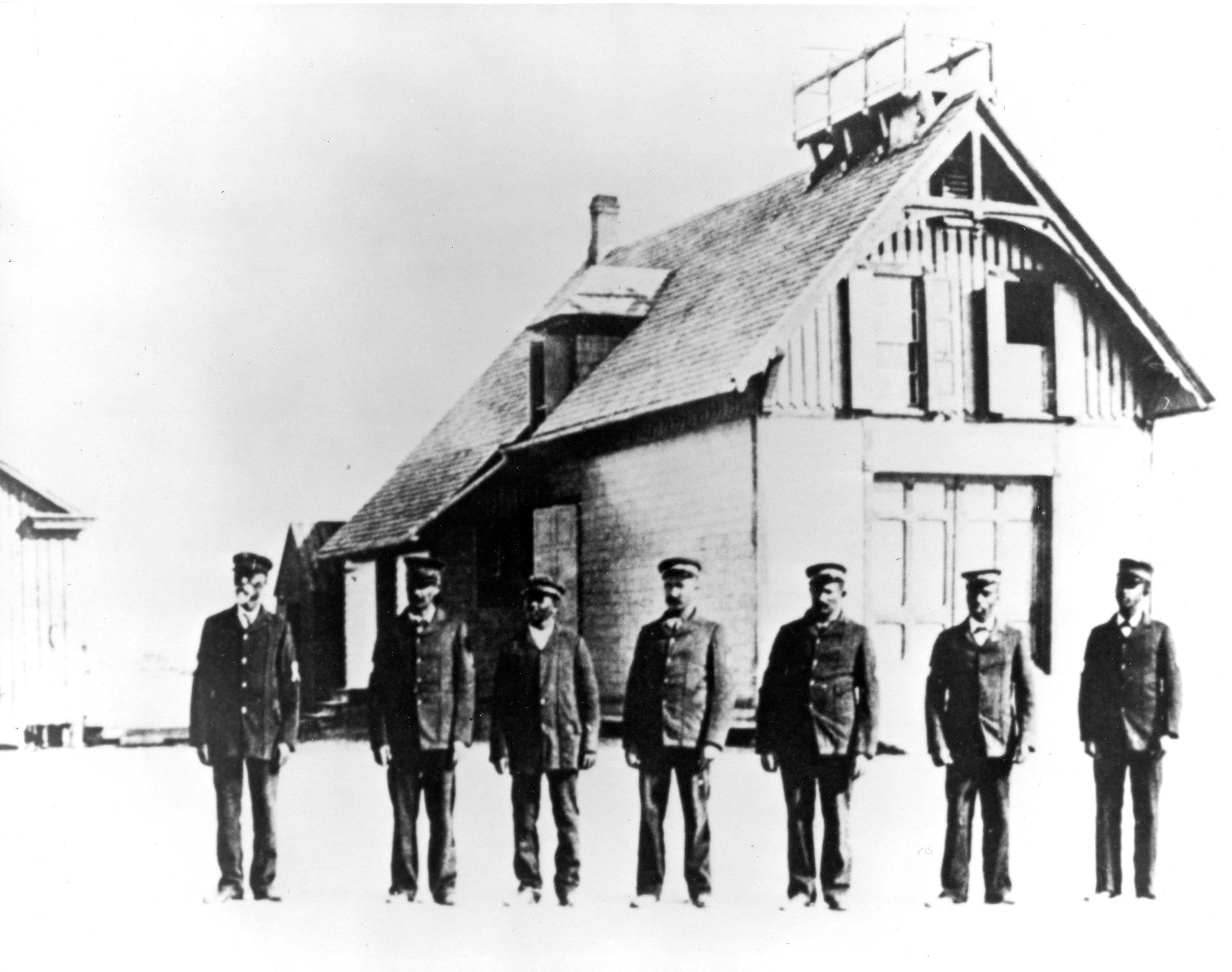 Richard Etheridge berdiri paling kiri, bersama kru penyelamat keturunan Afrika-Amerika, berdiri di depan Pos Penyelamat Pulau Pea Circa 1890. Dokumentasi : U.S. Coast Guard photo.