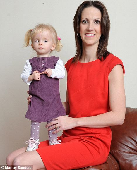 Abbie with mother Emma. Abbie is nearly two but scarcely bigger than a doll, due to a rare genetic condition 