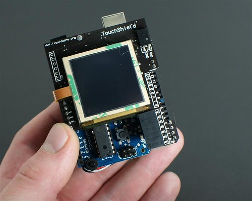 Holding the Arduino TouchShield Lithium Backpack by you.