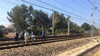 Usuaris de l'R16 caminant per la via del tren