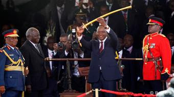 Kenya's President Uhuru Kenyatta (C) displays the special Rais Uhuru Kenyatta akikabidhiwa upanga wa mamlaka na rais wa zamani Mwai Kibaki