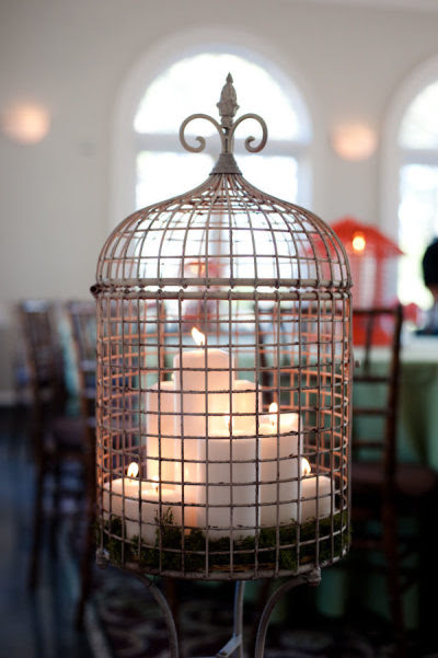 vintage bird cage filled with lit candles