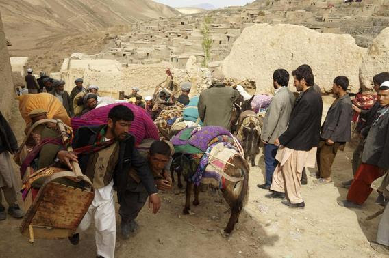 People walk with their belongings near the site of a landslide at Badakhshan province May 3, 2014. REUTERS/Stringer