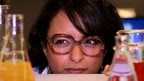 Reporter looking at test tubes