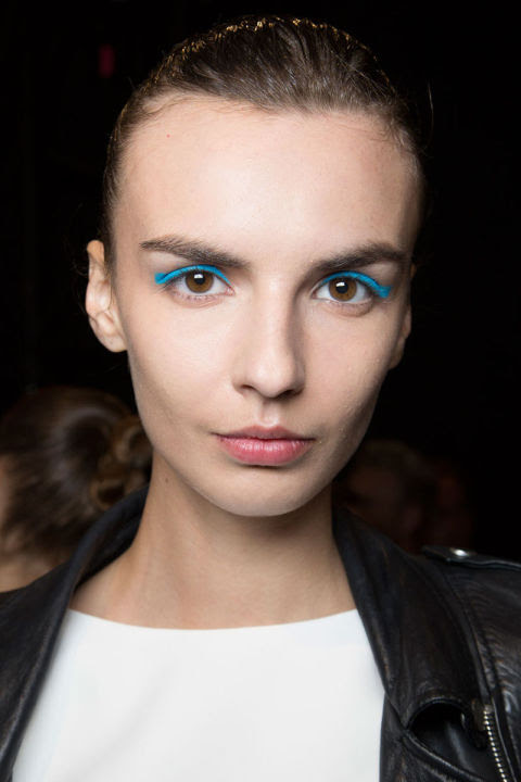 Any time a non-neutral pops up in a major way, the inevitable first question is: How do I wear it? The answer, when it comes to blue eye makeup, is any way you want. Go smoky with sparkly navy, draw a heavy line of Yves Klein blue across your lids and for days when you want "a little bit of chaos" (and a lot of attention), the hit of cyan Val Garland gave the eyes at Monique Lhulilier (left) will do the trick. 
