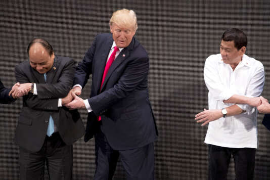Donald Trump, entre le premier ministre du Vietnam, Nguyen Xuan Phuc, et le président des Philippines, Rodrigo Duterte, a éprouvé des difficultés à effectuer le geste, le 13 novembre 2017.