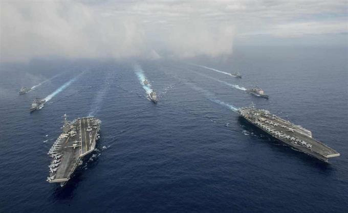 　１８日、護衛艦などを従えフィリピン海に展開する米海軍ニミッツ級航空母艦「ジョン・C・ステニス」（左）と「ロナルド・レーガン」（米海軍提供・ロイター）  