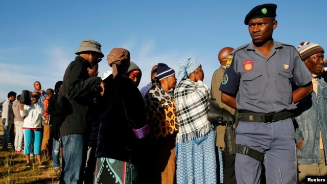 File - A police officer looks on at a voting station during the Lesotho national election in Magkhoakhoeng village outside the capital Maseru, Feb. 28, 2015.
