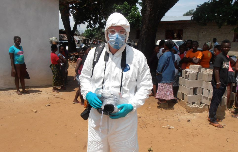 Getty Images staff photographer John Moore wears protective clothing, knows as personal protective equipment (PPE), before joining a Liberian burial team set to remove the body of an Ebola victim from her home