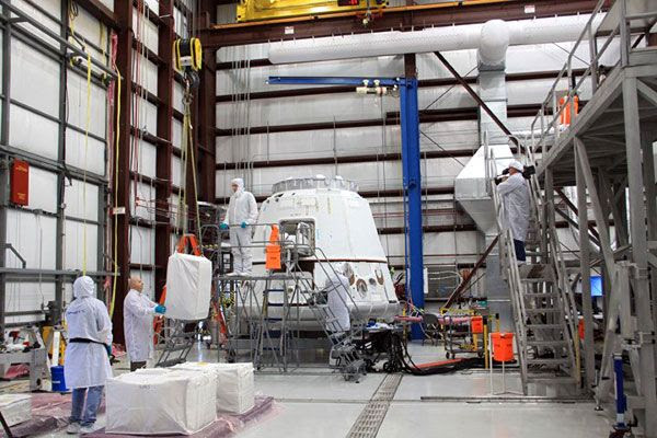SpaceX and NASA personnel work together to load cargo into the Dragon C2+ spacecraft, in early April of 2012.