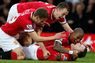Wayne Rooney (on ground) celebrates with Michael Carrick (L), Jonny Evans (top) and Ashley Young