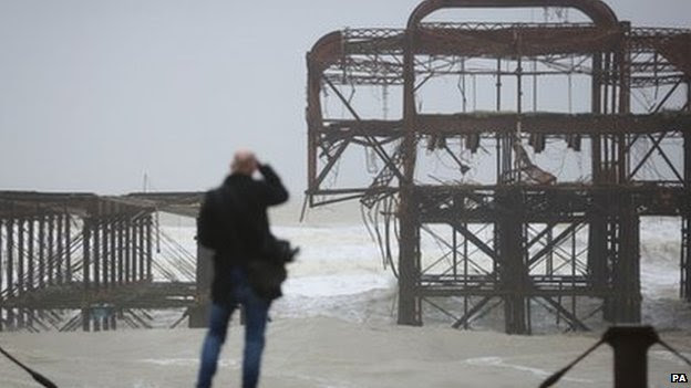 A man looks looks at damage to the Grade I listed West Pier in Brighton, East Sussex