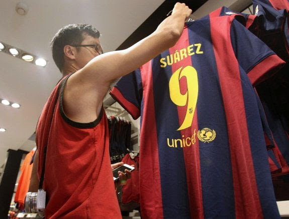 Un aficionado coge la camiseta de Suárez, que ya se ha puesto a la venta.
