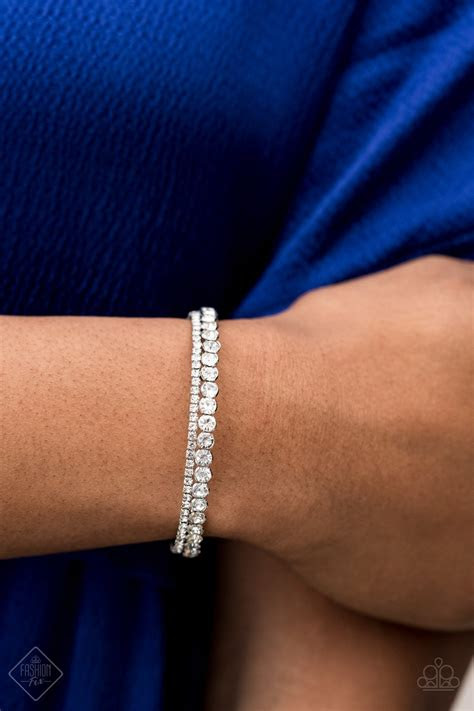 An array of glassy and polished red beading and mismatched silver accents are threaded along stretchy elastic bands, creating colorful layers across the . Fairytale Sparkle White Paparazzi Fashion Fix Bracelet May