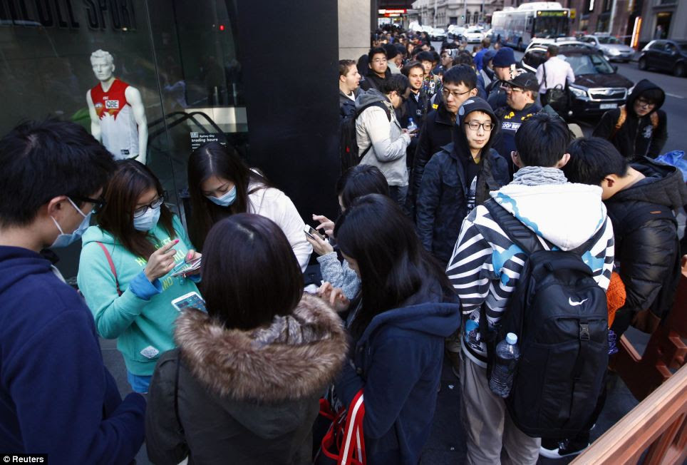 Tempers flare: Customers stand in a line outside the Apple store in Sydney this morning. One angry fan yelled at police outside the store, complaining about queue jumpers before officers moved him to the back of the line
