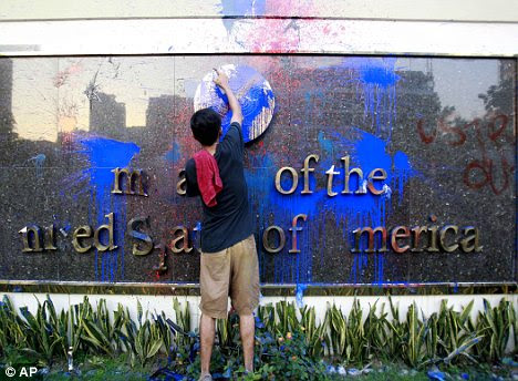 Damage: A student helps deface the seal outside the U.S. embassy building