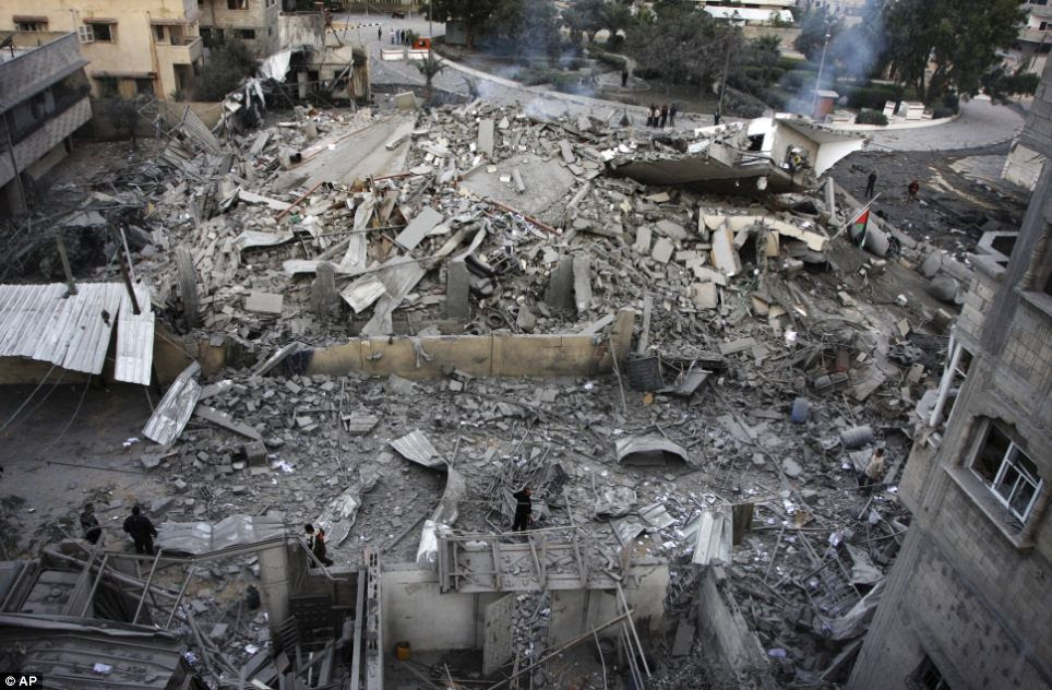 Palestinians inspect the damage at the office building of Hamas Prime Minister Ismail Haniyeh after being destroyed during an Israeli airstrike in Gaza