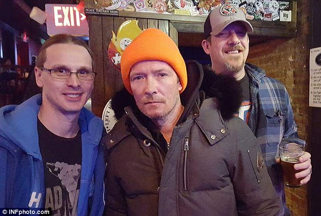 Battled addiction: Scott Weiland was pictured with fans at a bar ahead of his November 20 concert with The Wildabouts in Elmwood, Illinois. Eyewitnesses said he'd been drinking what looked like vodka before the show