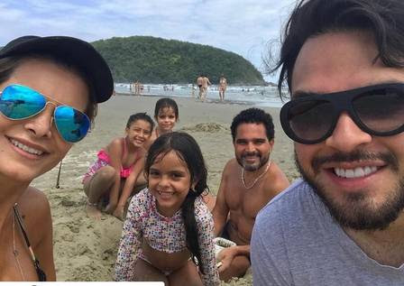 Cantor aparece sem camisa em férias com a mulher e os filhos