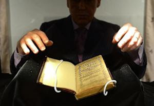 A Sotheby's employee handles a copy of the Bay Psalm …