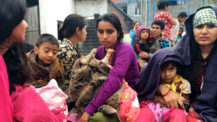 People wait at a school after a 7.7 magnitude earthquake struck, in Kathmandu, Nepal, April 25, 2015. (Reuters)