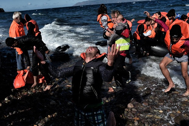 Homem reage ao chegar com outros refugiados e migrantes à ilha grega de Lesbos nesta quarta-feira (28) (Foto: Aris Messinis/AFP)