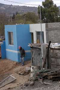 Viviendas precarias de la colonia Lomas del Pedregal, conocida como Cartolandia, en el municipio de Querétaro. Abajo, una de las casas de 42 metros cuadrados construidas con un esquema similar al del programa priísta Solidaridad: las autoridades municipales aportan materiales y asesoría y los beneficiarios mano de obra