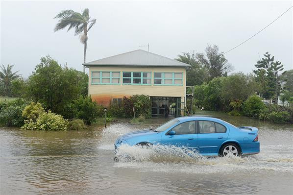 Warga menggunakan mobil pribadi mengungsi melewati genangan air yang menutup jalan dan halaman rumah. Mobil berusaha menerjang banjir di Chinderah, Australia, 28/1.