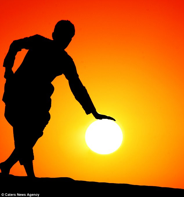 World in his hands: A man look like he is taking as rest on the sun 