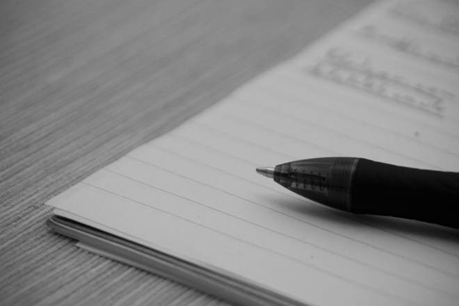 A pen laying across the bottom of a notebook